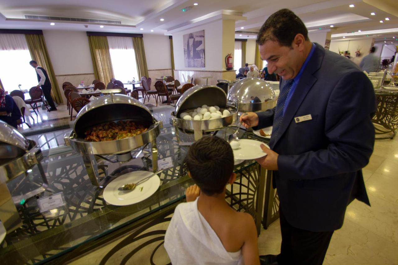 Grand Makkah Hotel La Mecque Extérieur photo A hotel manager serving food to a guest